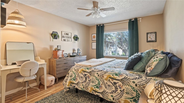 bedroom featuring hardwood / wood-style flooring, ceiling fan, and a textured ceiling