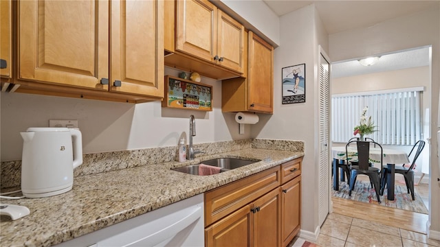 kitchen with light stone countertops, sink, and light tile patterned floors