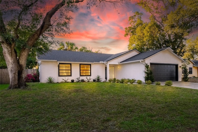 ranch-style house featuring a yard and a garage