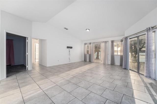 tiled spare room featuring lofted ceiling