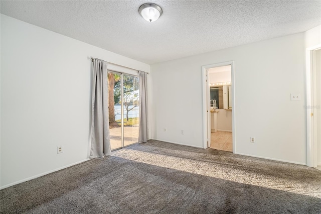 carpeted spare room with a textured ceiling