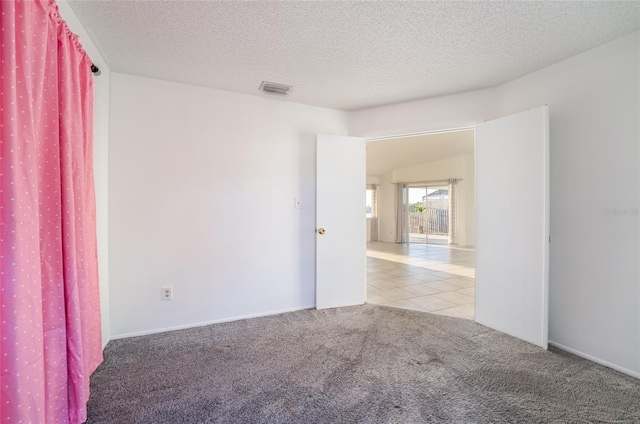 carpeted spare room with a textured ceiling