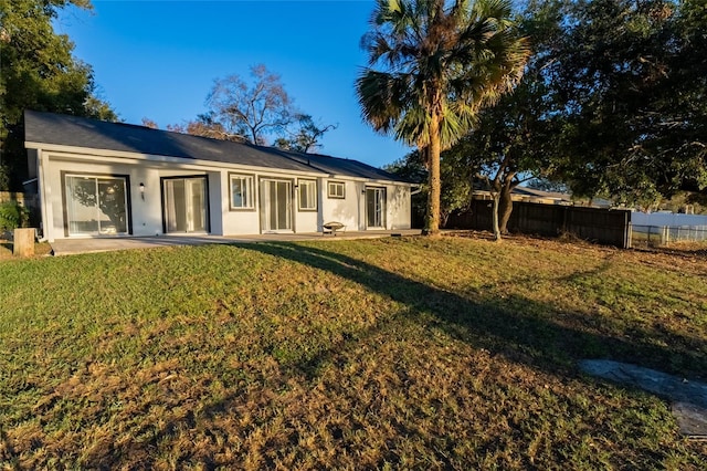 back of property featuring a patio area and a lawn