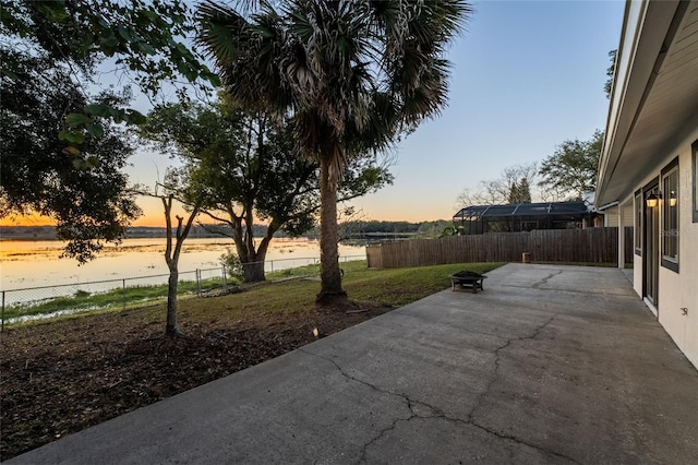 patio terrace at dusk featuring a water view