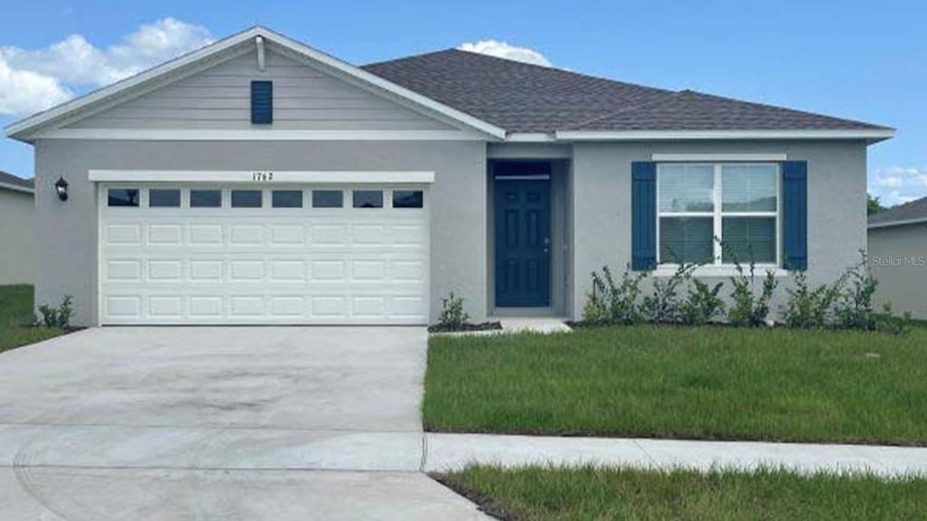 view of front of home with a garage and a front lawn