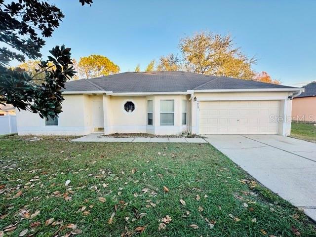 single story home featuring a front lawn and a garage