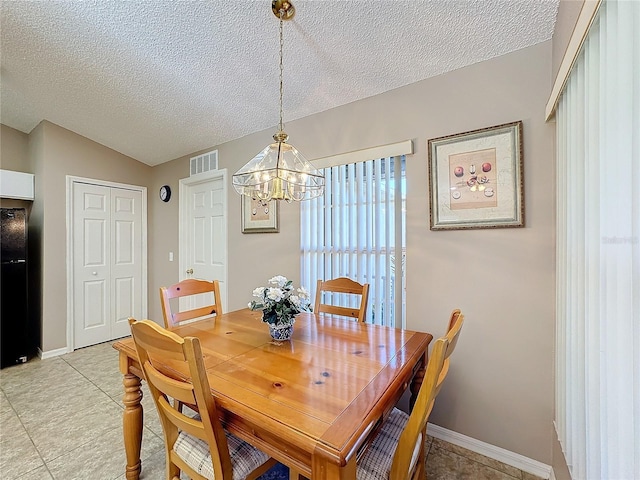 dining room with a chandelier and a textured ceiling