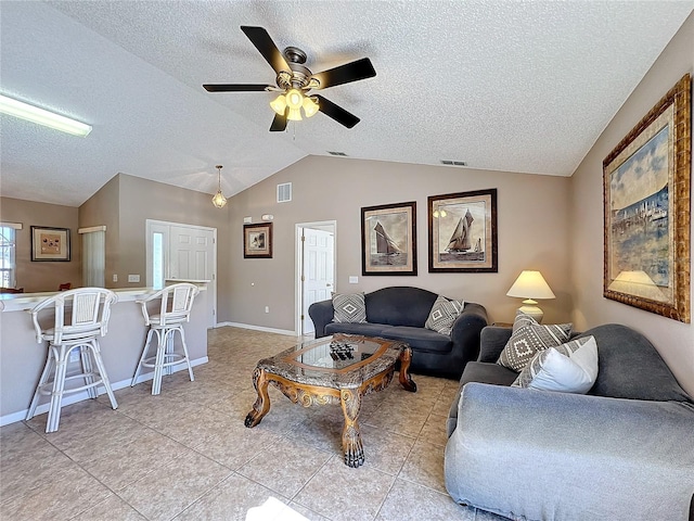 tiled living room featuring ceiling fan, lofted ceiling, and a textured ceiling