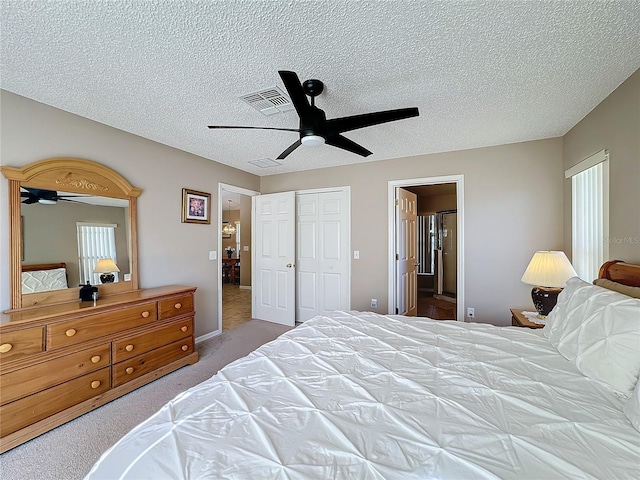 bedroom with light carpet, a textured ceiling, a closet, and ceiling fan