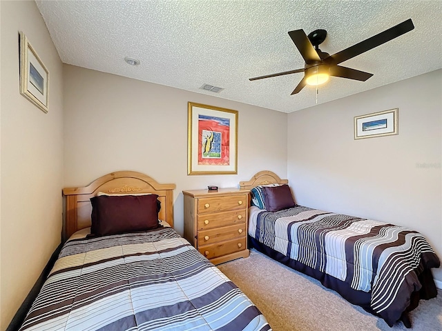 carpeted bedroom with a textured ceiling and ceiling fan