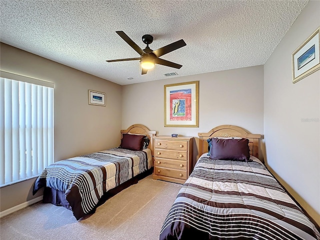 carpeted bedroom with ceiling fan and a textured ceiling