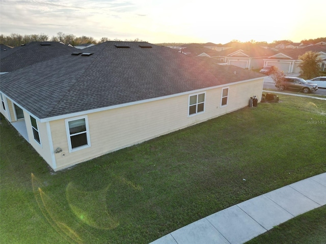 property exterior at dusk with a yard