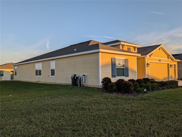 view of side of home with a garage and a lawn