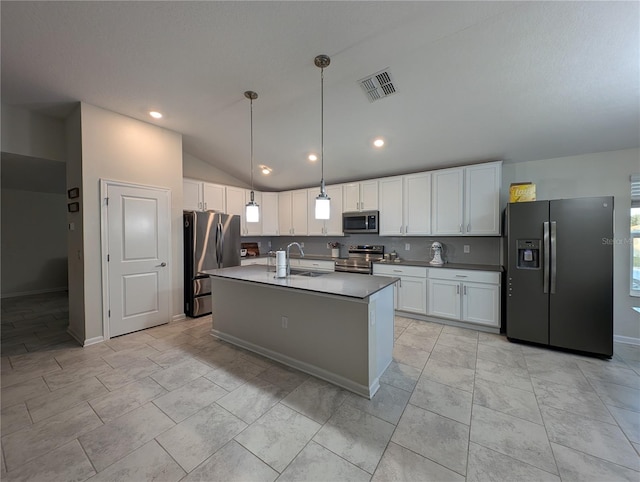 kitchen with a kitchen island with sink, hanging light fixtures, vaulted ceiling, white cabinetry, and stainless steel appliances