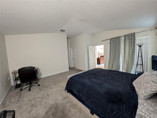 carpeted bedroom with lofted ceiling and a textured ceiling