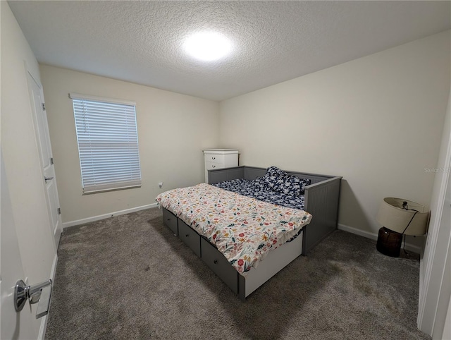 bedroom featuring dark colored carpet and a textured ceiling