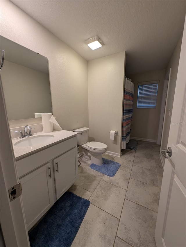 bathroom with a shower with curtain, vanity, a textured ceiling, and toilet