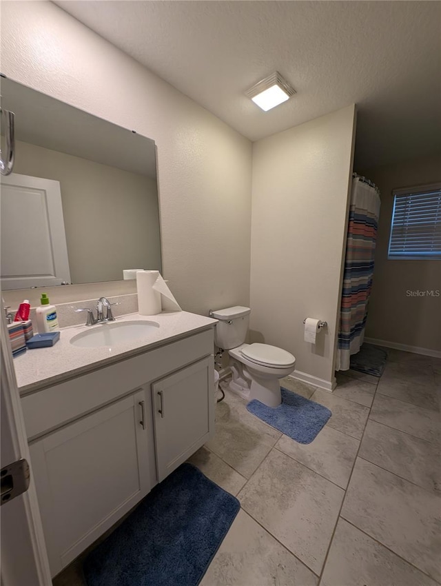 bathroom with tile patterned floors, vanity, a textured ceiling, and toilet