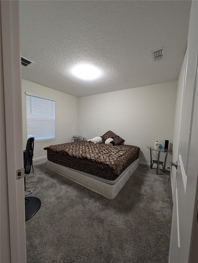 carpeted bedroom featuring a textured ceiling