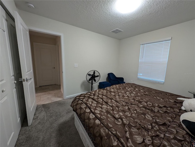 bedroom featuring carpet and a textured ceiling