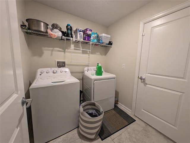 washroom with washing machine and clothes dryer and light tile patterned flooring