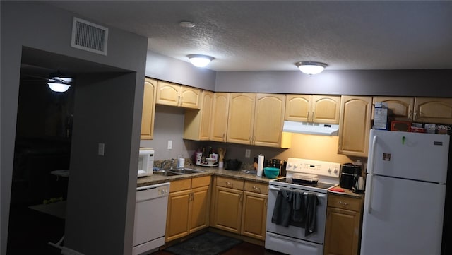 kitchen with a textured ceiling, white appliances, light brown cabinetry, and sink