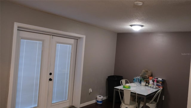 dining area featuring french doors and a textured ceiling