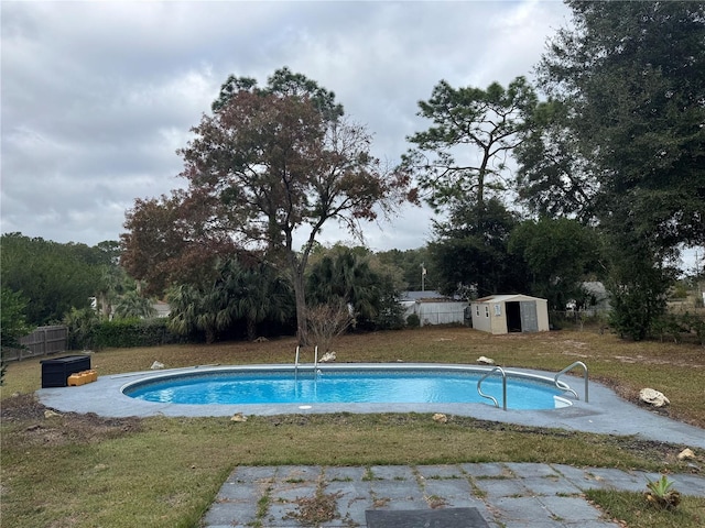 view of swimming pool featuring a yard, a diving board, and a storage shed