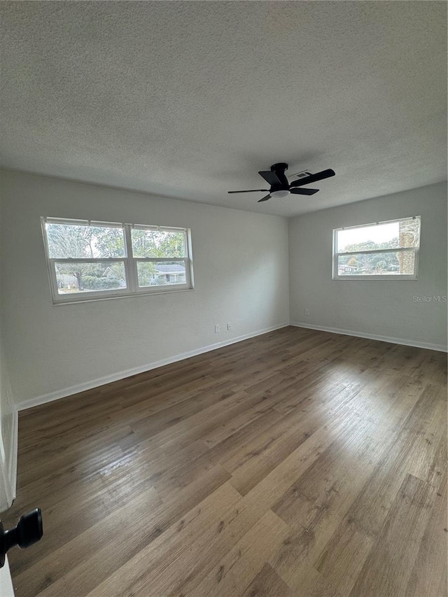 spare room featuring hardwood / wood-style flooring, ceiling fan, and a textured ceiling