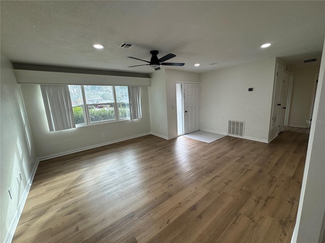 empty room featuring a textured ceiling, hardwood / wood-style flooring, and ceiling fan