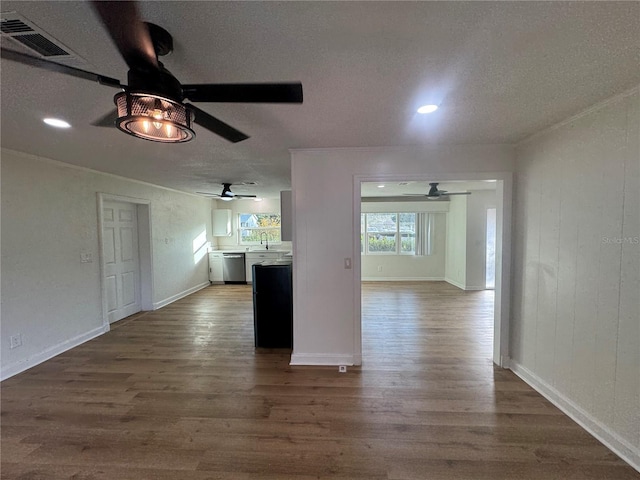 unfurnished living room with a textured ceiling, ceiling fan, sink, and dark hardwood / wood-style floors