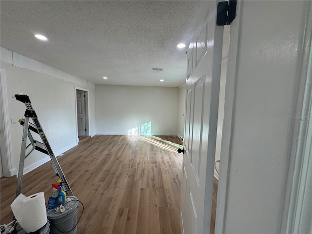 empty room with hardwood / wood-style floors and a textured ceiling