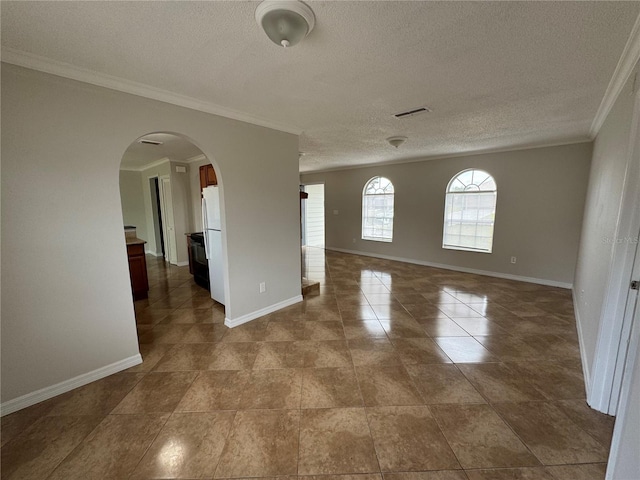 spare room featuring a textured ceiling and crown molding