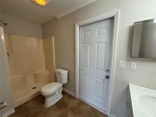 bathroom with tile patterned floors, vanity, crown molding, a shower, and toilet