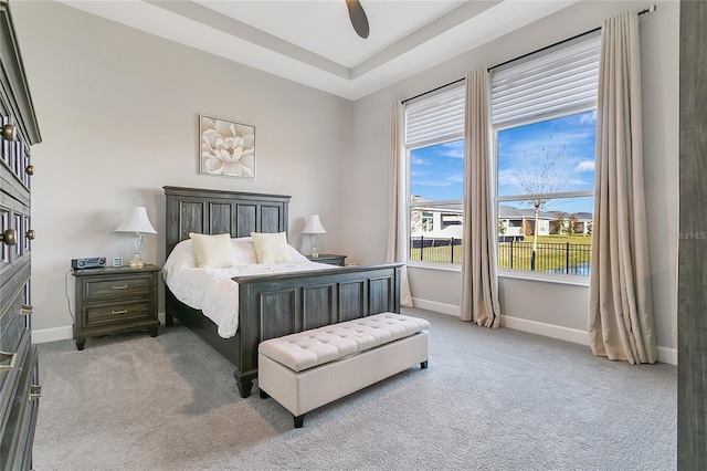 bedroom featuring carpet flooring, ceiling fan, and a raised ceiling