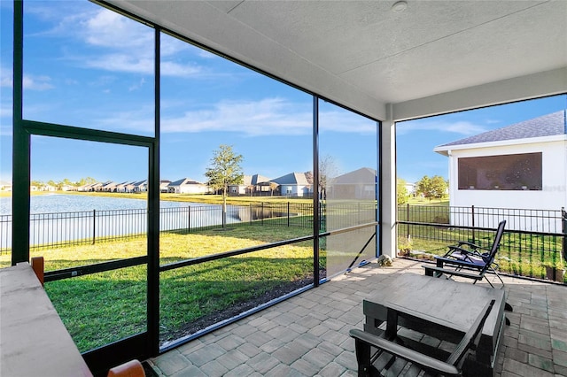 sunroom featuring plenty of natural light and a water view