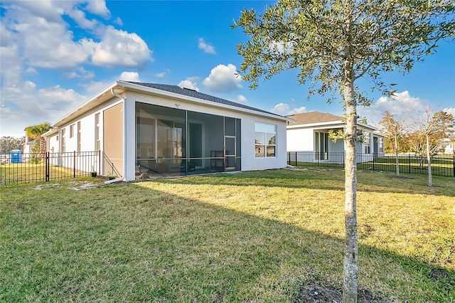 rear view of house with a sunroom and a yard