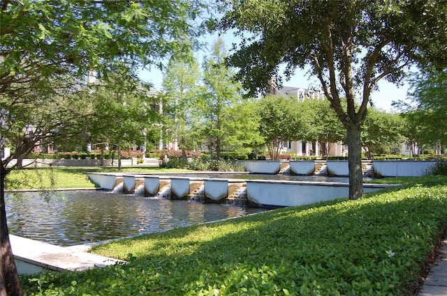 view of home's community with a water view and a yard