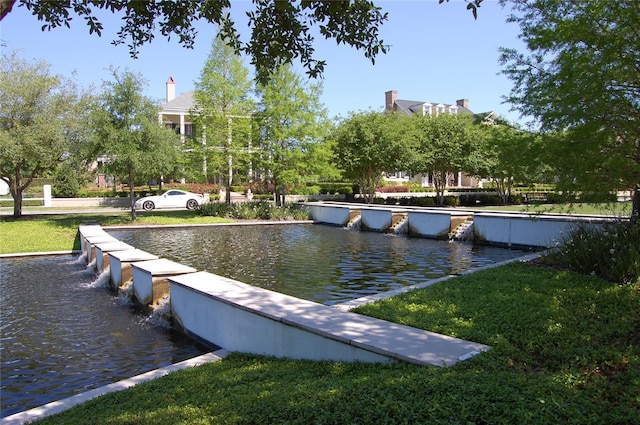 view of community featuring a lawn and a water view