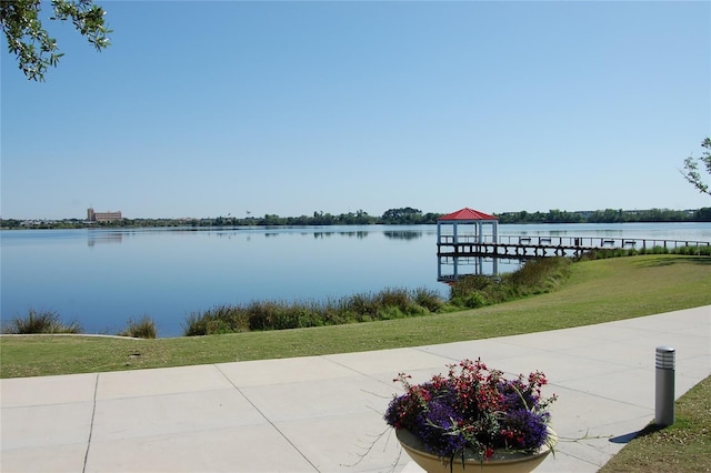 view of dock with a water view and a yard