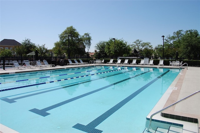 pool with a patio and fence