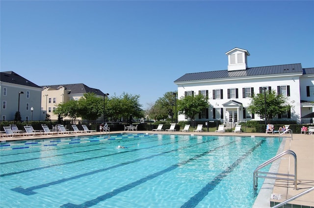 community pool with a patio and fence