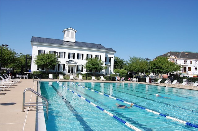 community pool featuring a patio area and fence