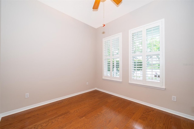 empty room with dark wood-style flooring, baseboards, and a ceiling fan