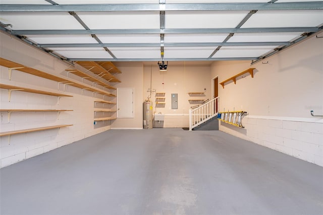 garage with a garage door opener, concrete block wall, electric panel, and water heater
