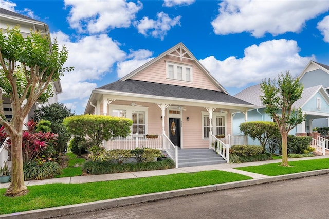 bungalow-style home with covered porch and roof with shingles