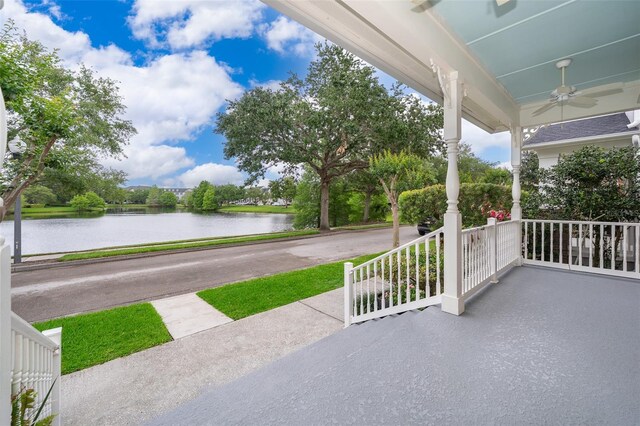 view of patio with a water view, a porch, and ceiling fan