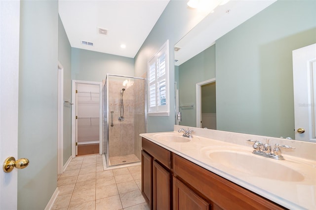 bathroom featuring a spacious closet, visible vents, a sink, and a stall shower