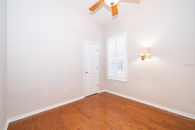 empty room with wood finished floors, ceiling fan, and baseboards