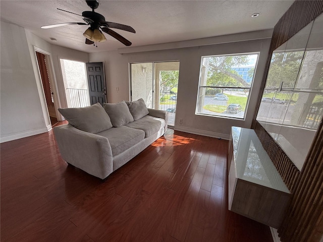 living room with ceiling fan and dark wood-type flooring